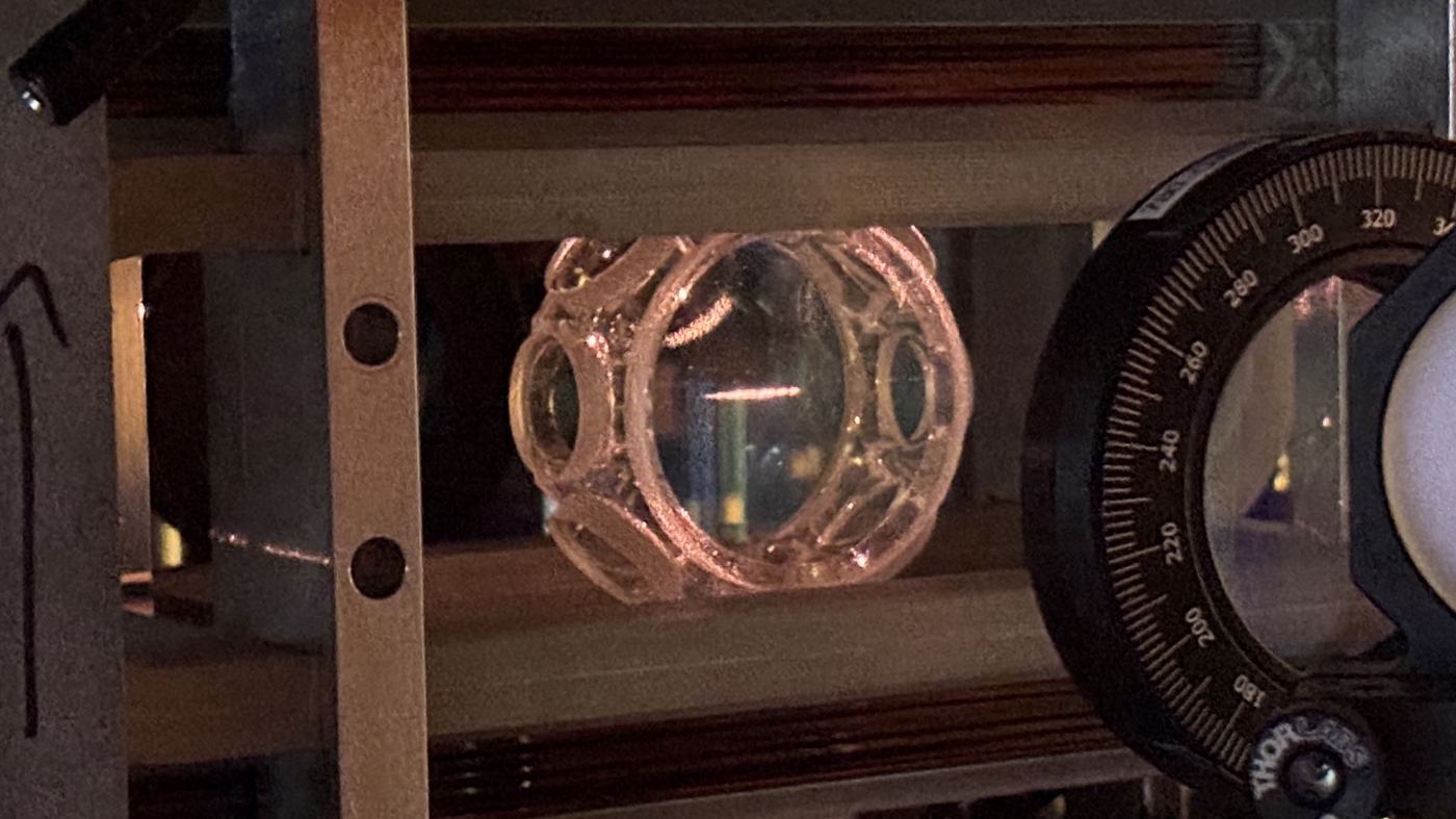 The magneto-optical trap's glass cell, atoms fluorescing